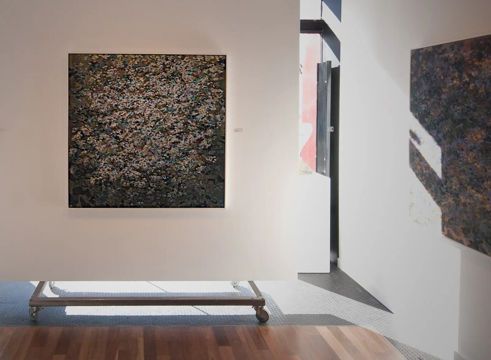 Abstract paintings seen across adjoining gallery walls