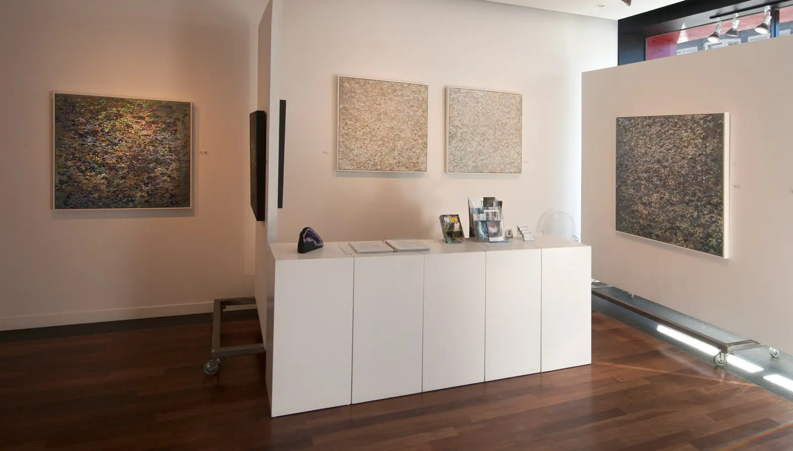 Paintings installed around a bright gallery interior