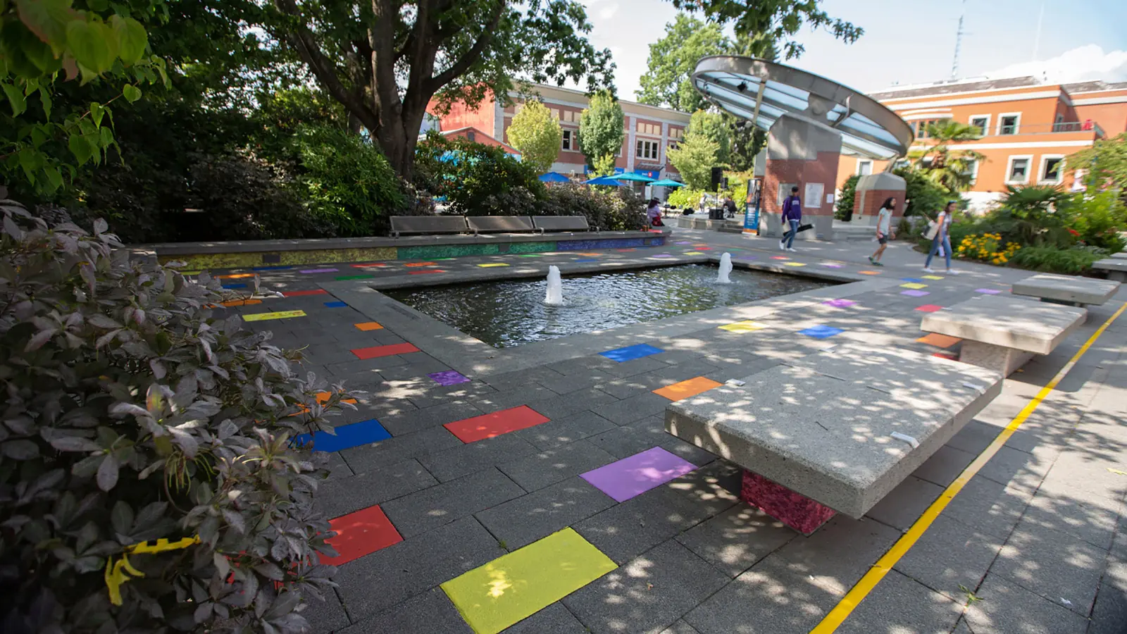 Colourful painted bands crossing a public plaza around a fountain