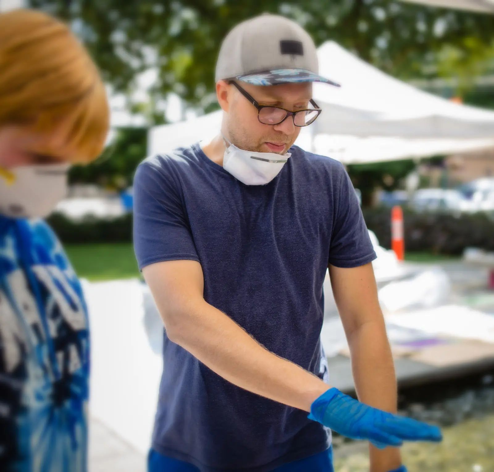 Artist wearing gloves while working outdoors at the public project