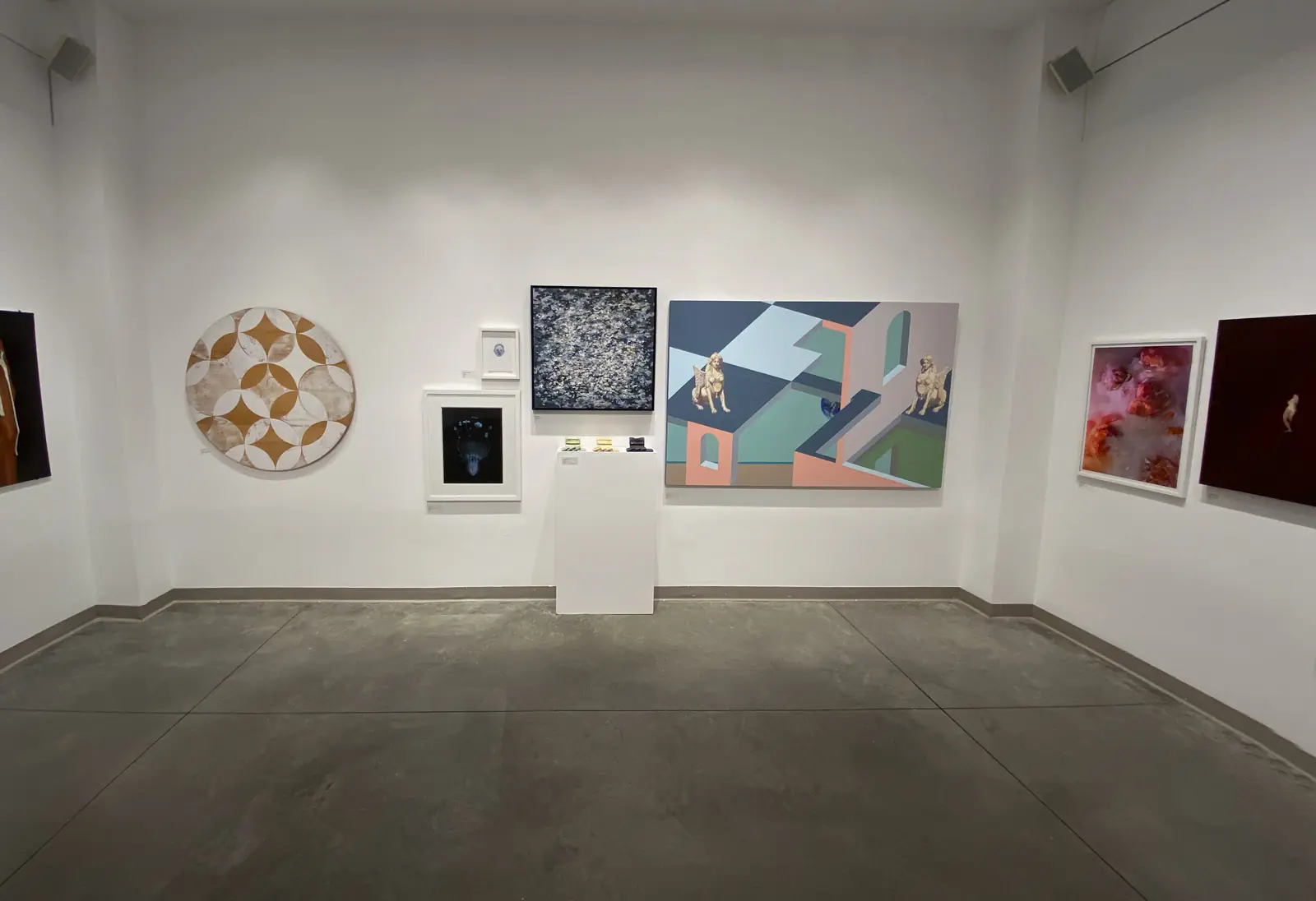 Mixed works arranged across two gallery walls