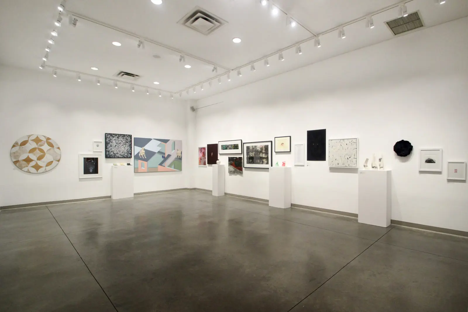 Wide view of works installed around a white gallery